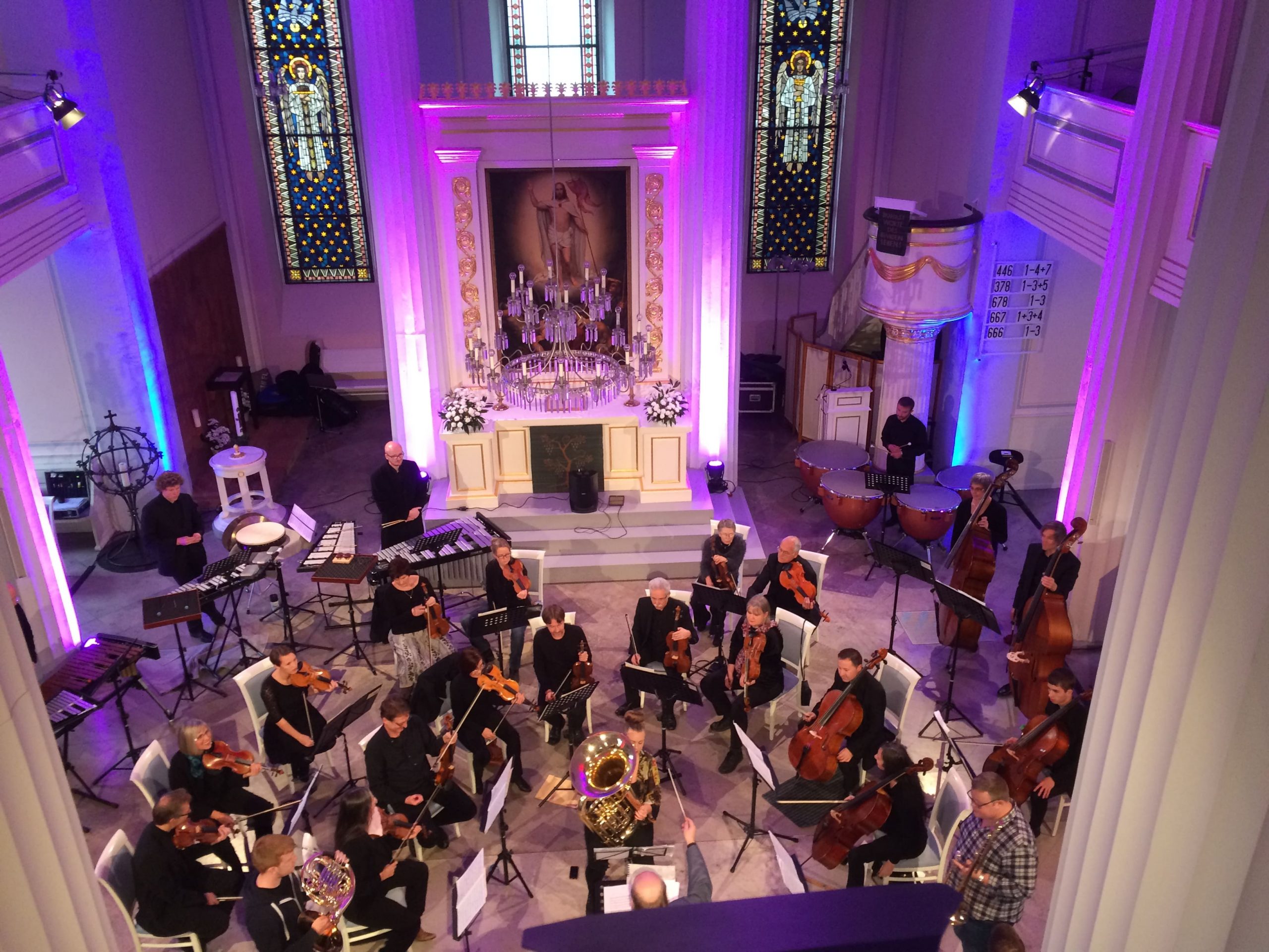 Ein Orchester spielt im Kirchenschiff, das durch die Beleuchtung ein tolles Ambiente ergibt.